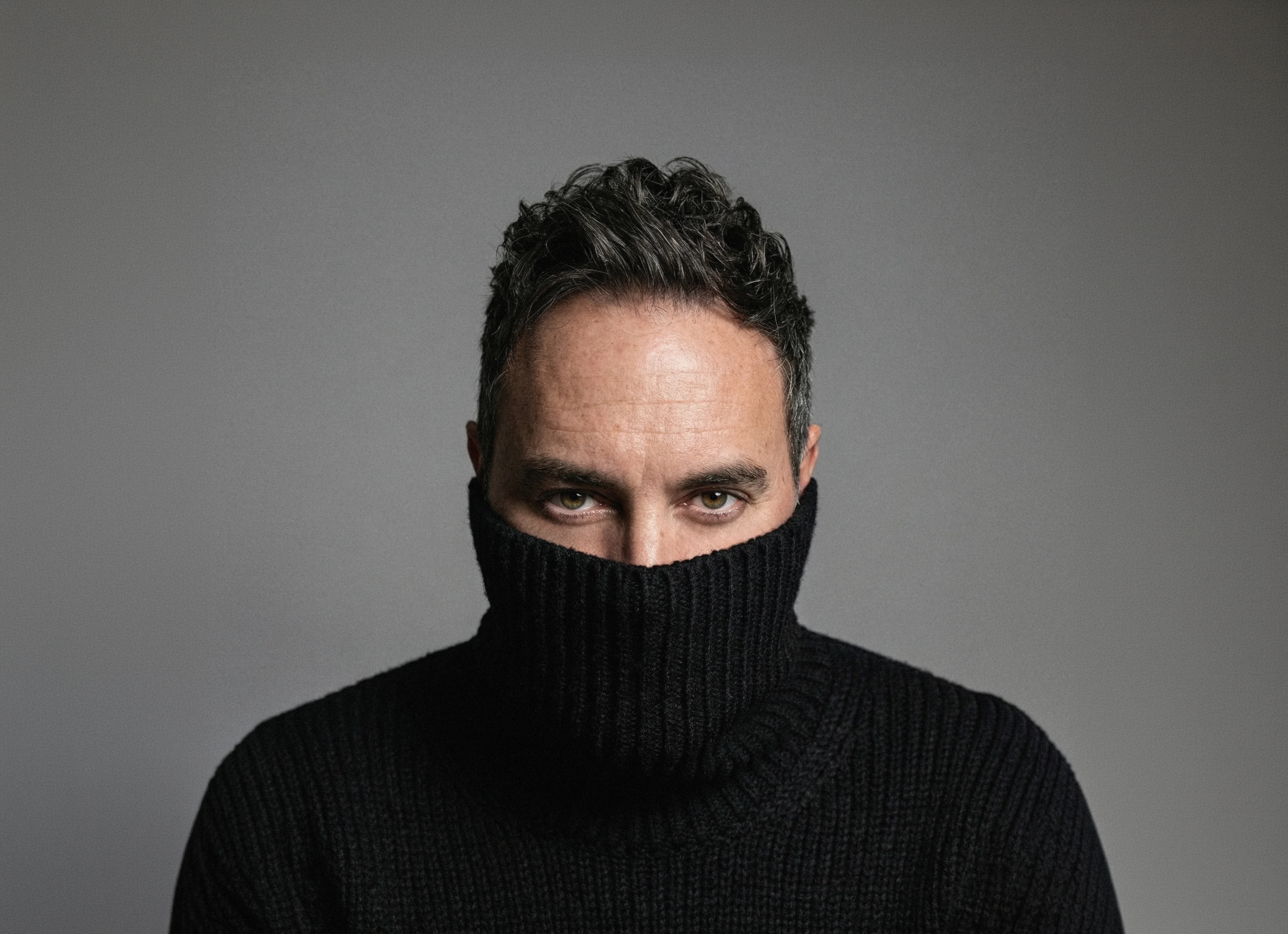 K_SICK portrait, face half hidden in a black roll-neck sweater